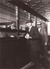 Vintage photograph circa 1900's showing dapper man at teller line