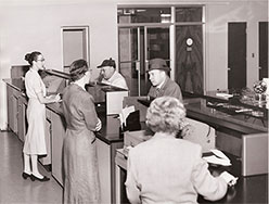 Vintage photo circa 1950's of tellers serving customer at teller line